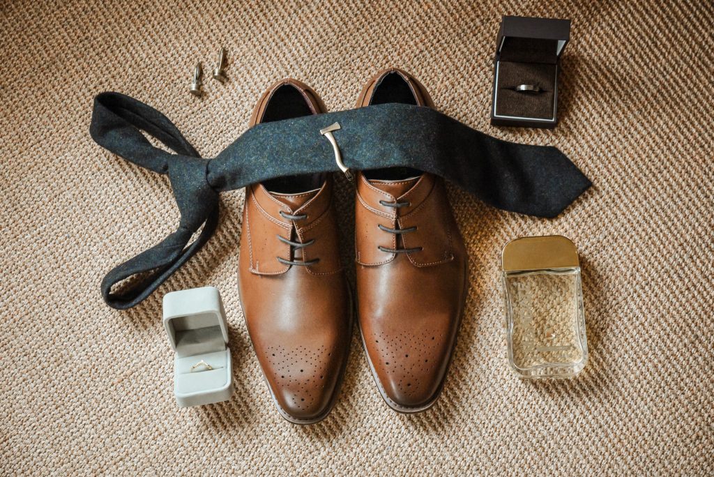 Flatlay of groom’s wedding details including tie, cufflinks, and boutonniere at Drenagh Estate
