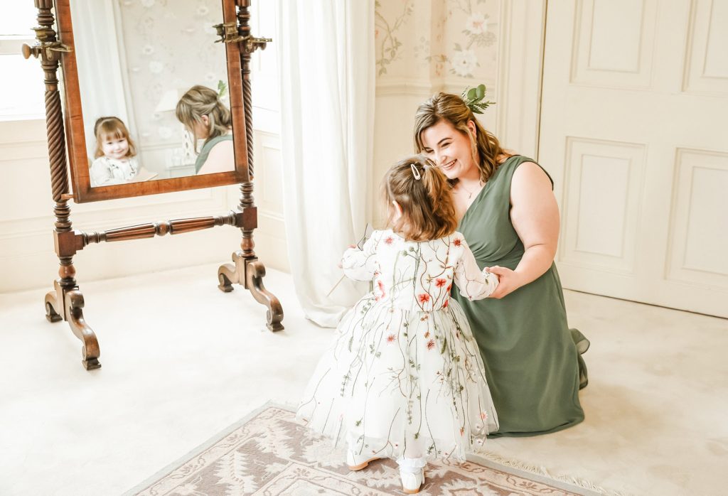 Flower girl in white dress smiling during wedding at Drenagh Estate in Northern Ireland