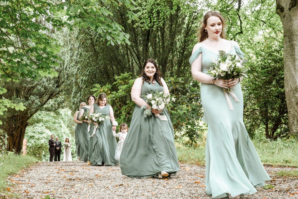 Bridesmaids in Azazie dresses walking with the bride at Drenagh Estate wedding