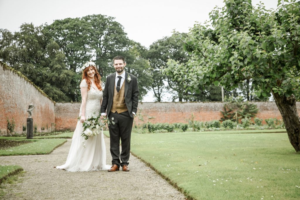 Bride and groom walking through the gardens at Drenagh Estate during their wedding in Northern Ireland
