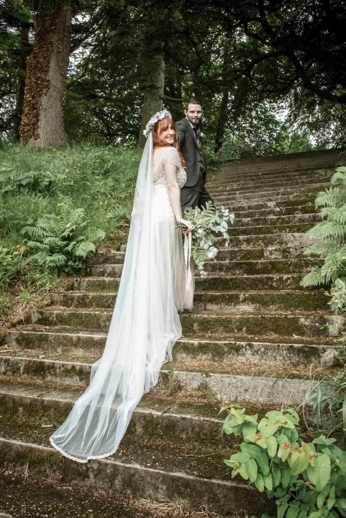 Bride and groom walking up the stairs in the gardens at Drenagh Estate during their wedding in Northern Ireland