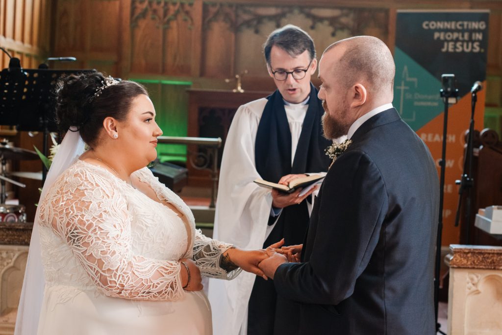 Bride and groom exchanging rings at St Donard’s Community Church, Dundrum