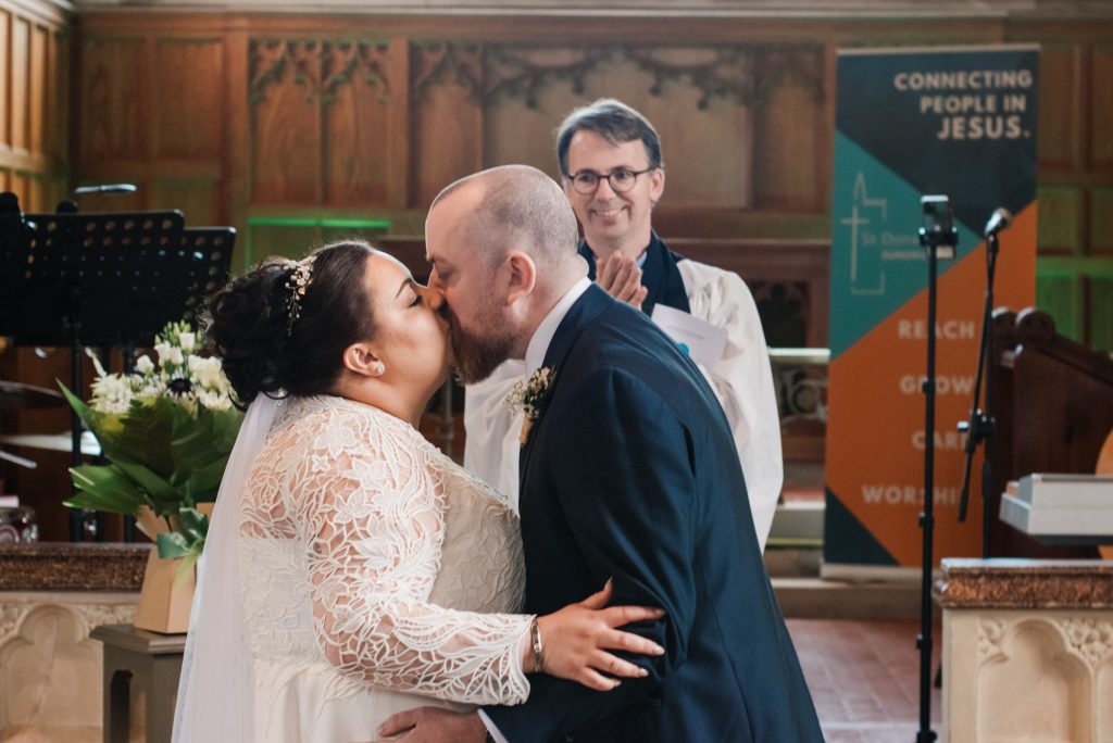 Bride's and groom's first kiss after the church ceremony