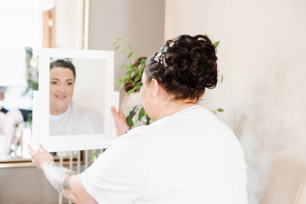 Candid moment of bride smiling while preparing for wedding day