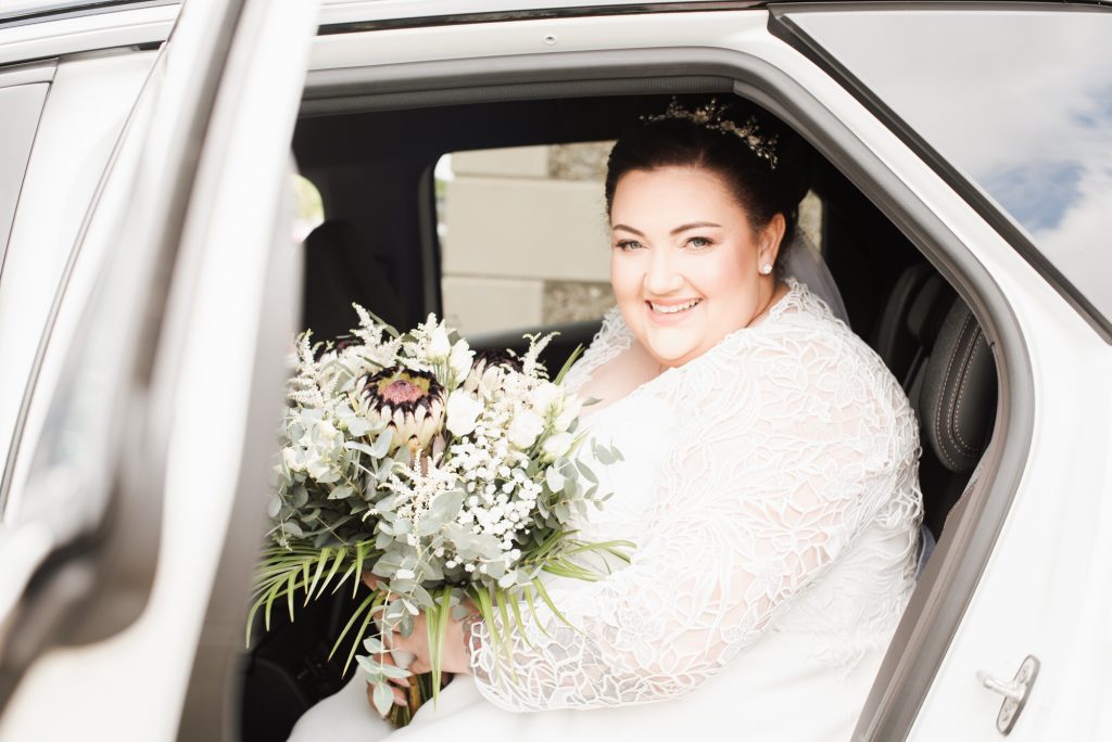 Candid moment of bride smiling while preparing for wedding day