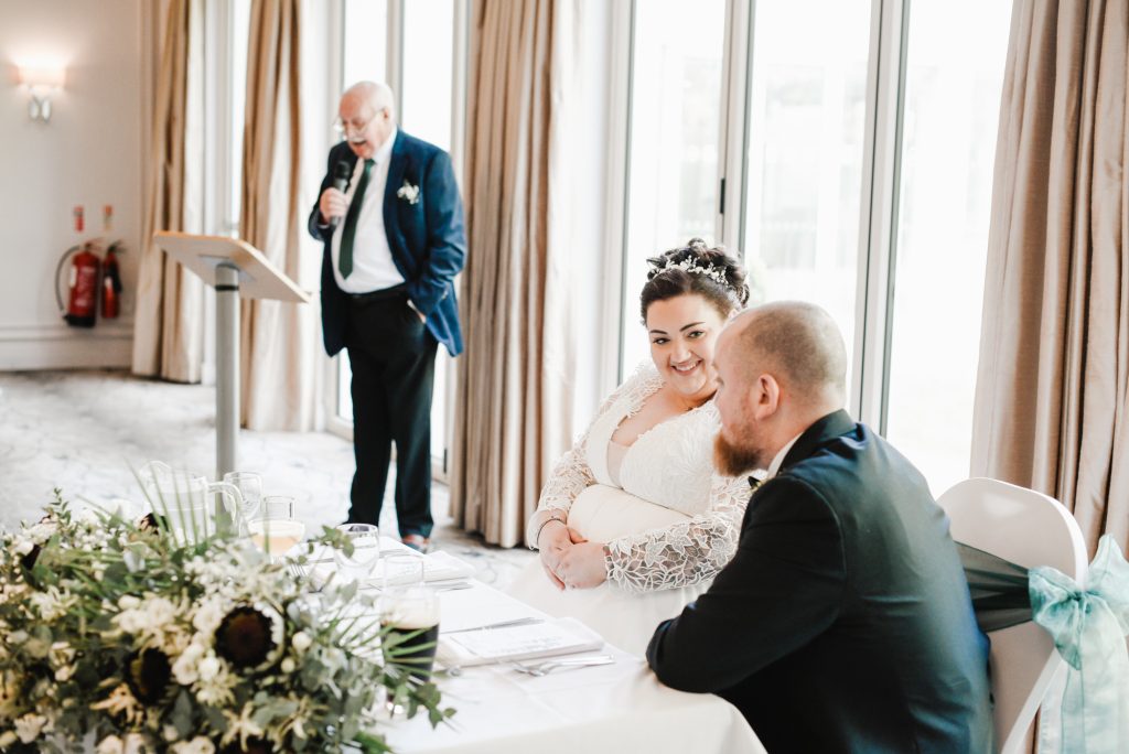 Happy couple enjoying a special moment of bride's father's speech at Millbrook Lodge